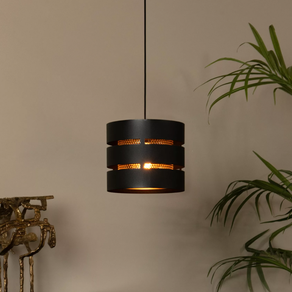 Zwarte ronde hanglamp met één lichtpunt en warme gloed in woonkamer