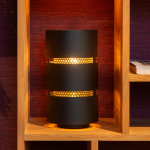 Zwarte ronde tafellamp met geperforeerde metalen kap in houten wandrek