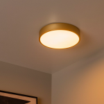 Gouden plafonnière met warmwit licht in moderne interieurhoek