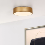 Goudkleurige plafonnière met ronde vorm en warmwit licht in moderne woonkamer