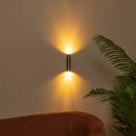 Moderne koffiebruine wandlamp met up en down lichteffect in woonkamerinterieur