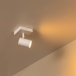 Witte metalen plafondlamp met één spot en warm licht in moderne kamer