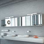 Witte moderne spiegellamp boven brede badkamerspiegel met dubbele wastafel