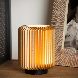 Goudkleurige metalen tafellamp met warme lichtgloed op houten tafel