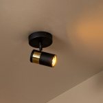 Zwarte en gouden plafondspot met één lichtpunt in warme verlichting