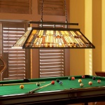 Hanglamp Tiffany met glas-in-lood kap boven biljarttafel in warme interieursetting
