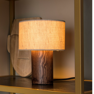 Tafellamp van naturel hout met linnen kap op donkere plank