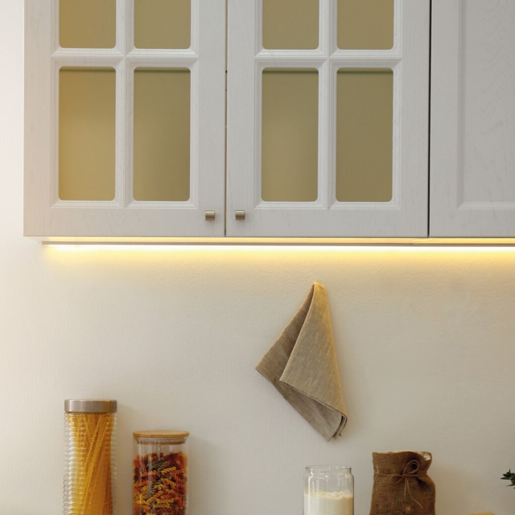 Onderbouwverlichting met warm witte LED-strip onder keukenkast in lichte keukenruimte