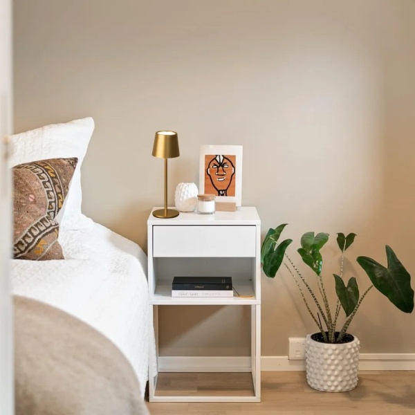 4052231508462_sfeerbeeld_005 Gouden oplaadbare tafellamp met smalle voet naast bed in moderne slaapkamer