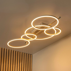 Ronde taupe plafonnière met LED ringen in warme lichtkleur boven houten wandpanelen